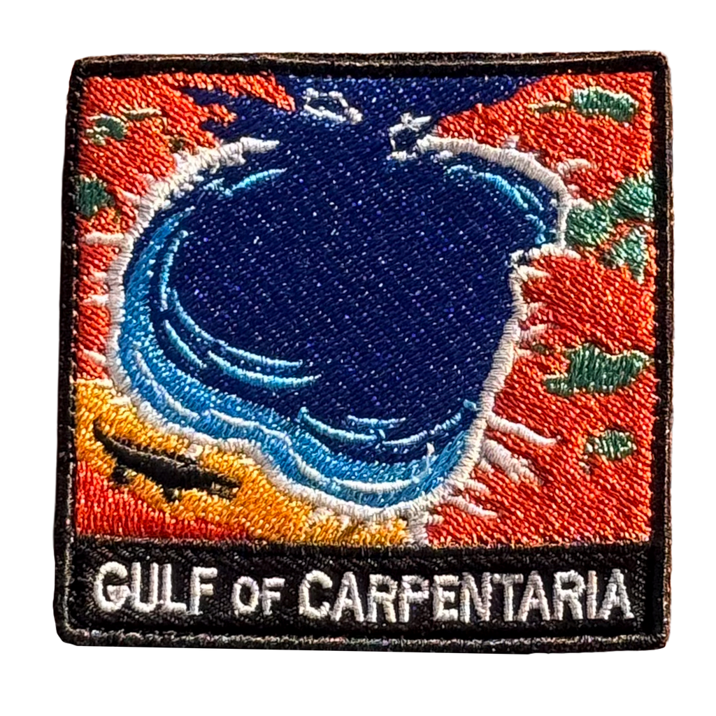 Gulf of Carpentaria embroidered travel patch with a barramundi and tropical coastline; photographed on a transparent background.