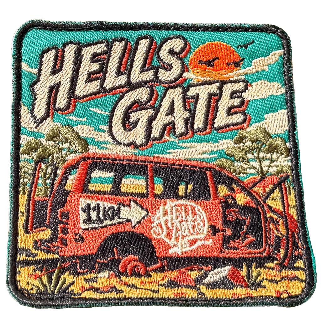 Hells Gate embroidered travel patch with a rusty outback vehicle beside an 11 km sign at Hells Gate; photographed on a transparent background.