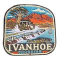 Ivanhoe Crossing embroidered travel patch with a four-wheel drive splashing across a flooded causeway with a crocodile in the water; photographed on a transparent background.