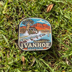 Ivanhoe Crossing embroidered travel patch with a four-wheel drive splashing across a flooded causeway with a crocodile in the water.