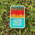 James Price Point embroidered travel patch with layered red coastal cliffs, turquoise water and a dark green treeline.