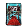 Joop's Jetty - Harrietville embroidered travel patch with a wooden jetty and Joop‚Äôs Jetty sign above a lake with a canoe; photographed on a transparent background.