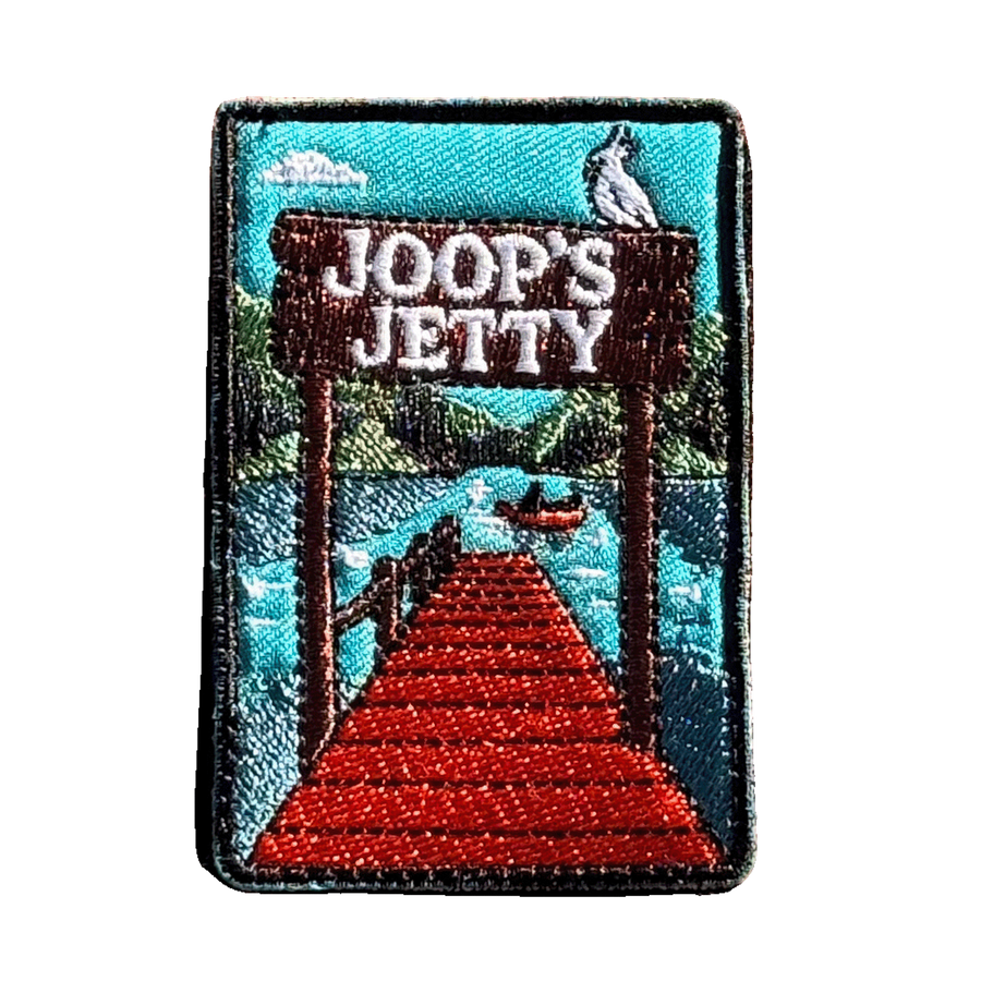 Joop's Jetty - Harrietville embroidered travel patch with a wooden jetty and Joop‚Äôs Jetty sign above a lake with a canoe; photographed on a transparent background.