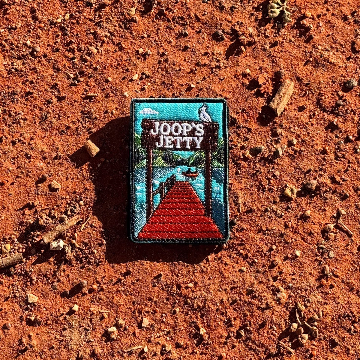 Joop's Jetty - Harrietville embroidered travel patch with a wooden jetty and Joop‚Äôs Jetty sign above a lake with a canoe.