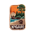 K'gari - Fraser Island embroidered travel patch with a shipwreck on the beach, a dingo paw print and green coastal forest; photographed on a transparent background.