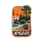 K'gari - Fraser Island embroidered travel patch with a shipwreck on the beach, a dingo paw print and green coastal forest; photographed on a transparent background.