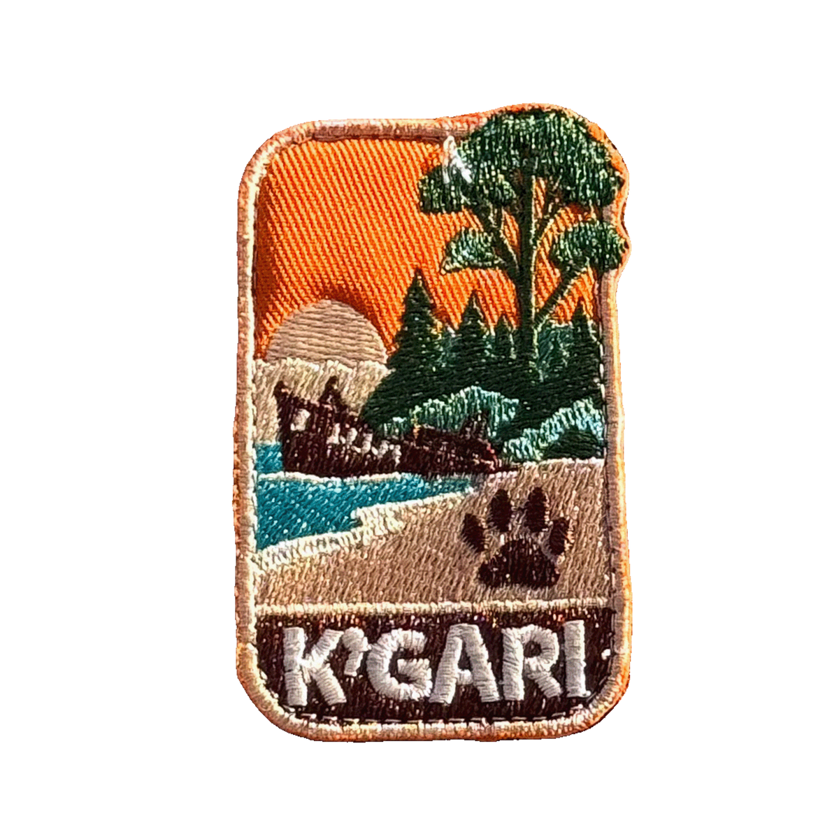 K'gari - Fraser Island embroidered travel patch with a shipwreck on the beach, a dingo paw print and green coastal forest; photographed on a transparent background.
