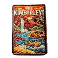 The Kimberleys embroidered travel patch with a waterfall, helicopter, cattle and four-wheel drive in a rugged Kimberley gorge; photographed on a transparent background.