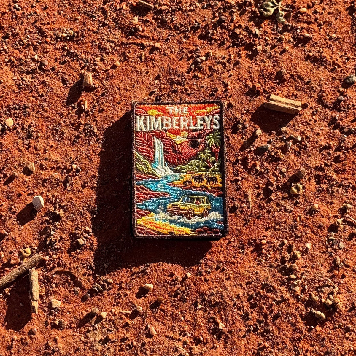 The Kimberleys embroidered travel patch with a waterfall, helicopter, cattle and four-wheel drive in a rugged Kimberley gorge.