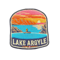 Lake Argyle embroidered travel patch with a swimmer overlooking Lake Argyle and distant mountains at sunset; photographed on a transparent background.