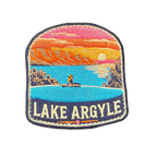 Lake Argyle embroidered travel patch with a swimmer overlooking Lake Argyle and distant mountains at sunset; photographed on a transparent background.