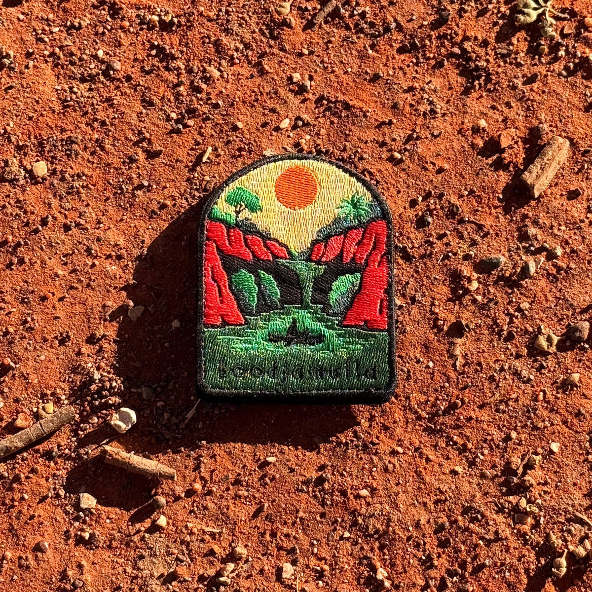 Lawn Hill (Boodjamulla) embroidered travel patch with a person canoeing through a green river between red cliffs at Boodjamulla.