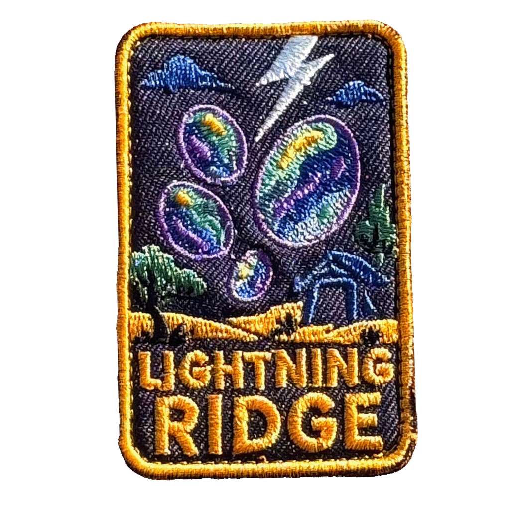 Lightning Ridge embroidered travel patch with colourful opals, lightning and a small mining shack beneath a dark sky; photographed on a transparent background.