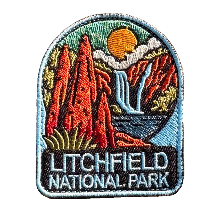 Litchfield National Park embroidered travel patch with red termite mounds, a waterfall and rocky scenery in Litchfield National Park; photographed on a transparent background.