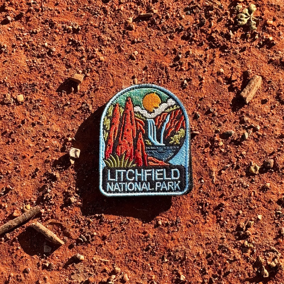 Litchfield National Park embroidered travel patch with red termite mounds, a waterfall and rocky scenery in Litchfield National Park.