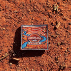 Longreach embroidered travel patch with a map-style outback landscape with a winding river, aircraft and Longreach Outback Hub lettering.