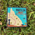 Matilda Way embroidered travel patch with a Queensland route map from Barringun to Kurumba, with a windmill, cattle and a boat.
