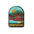 Moreton Bay embroidered travel patch with mangrove trees with exposed roots beside calm coastal water at sunset; photographed on a transparent background.
