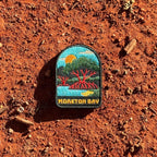 Moreton Bay embroidered travel patch with mangrove trees with exposed roots beside calm coastal water at sunset.