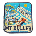 Mount Buller embroidered travel patch with a skier descending a snowy slope beneath chairlifts and a mountain village; photographed on a transparent background.