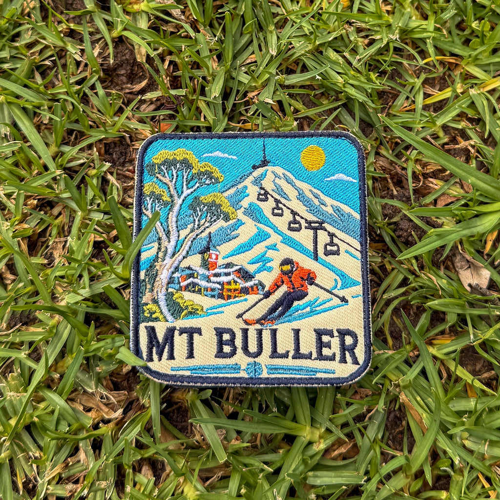 Mount Buller embroidered travel patch with a skier descending a snowy slope beneath chairlifts and a mountain village.