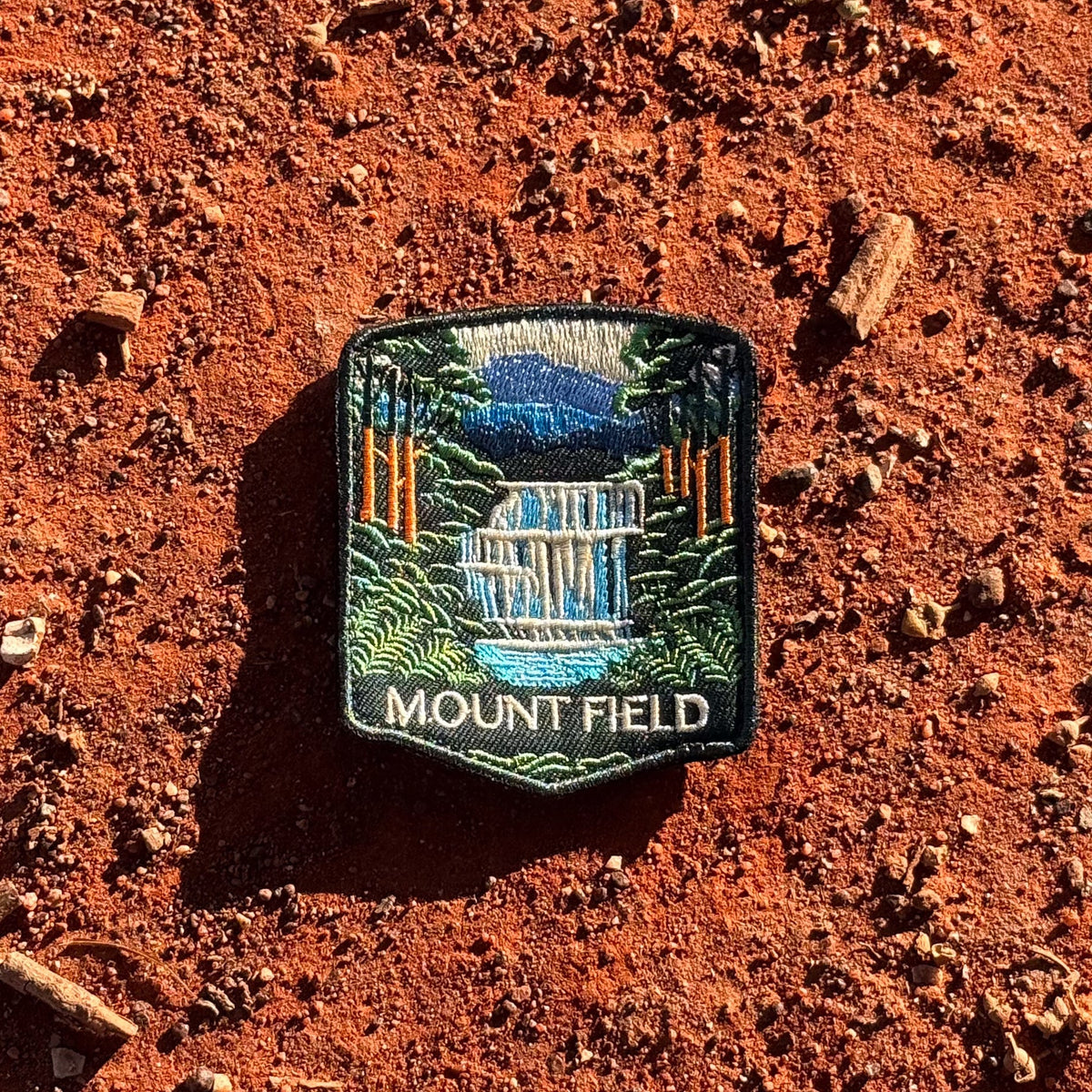 Mount Field National Park embroidered travel patch with a tiered waterfall surrounded by lush green forest.