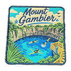 Mount Gambier embroidered travel patch with swimmers in a brilliant blue crater lake surrounded by limestone cliffs; photographed on a transparent background.