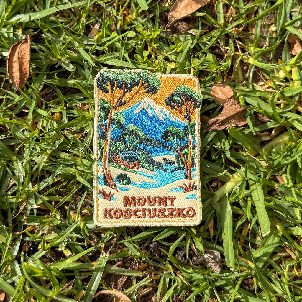 Mount Kosciouzko embroidered travel patch with a snow-covered mountain, alpine cabin, trees and a horse.