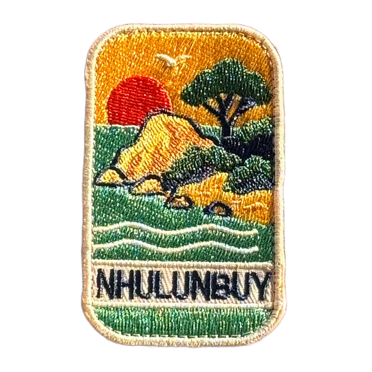 Nhulunbuy - Arnhem Land embroidered travel patch with a rocky tropical shoreline with trees, gentle waves and a setting sun; photographed on a transparent background.