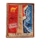 Nullarbor Plain embroidered travel patch with the 90 Mile Straight road between red desert with a camel and coastal cliffs with a whale; photographed on a transparent background.