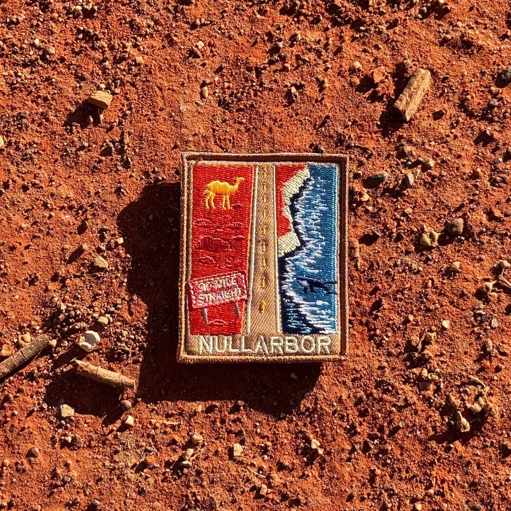Nullarbor Plain embroidered travel patch with the 90 Mile Straight road between red desert with a camel and coastal cliffs with a whale.