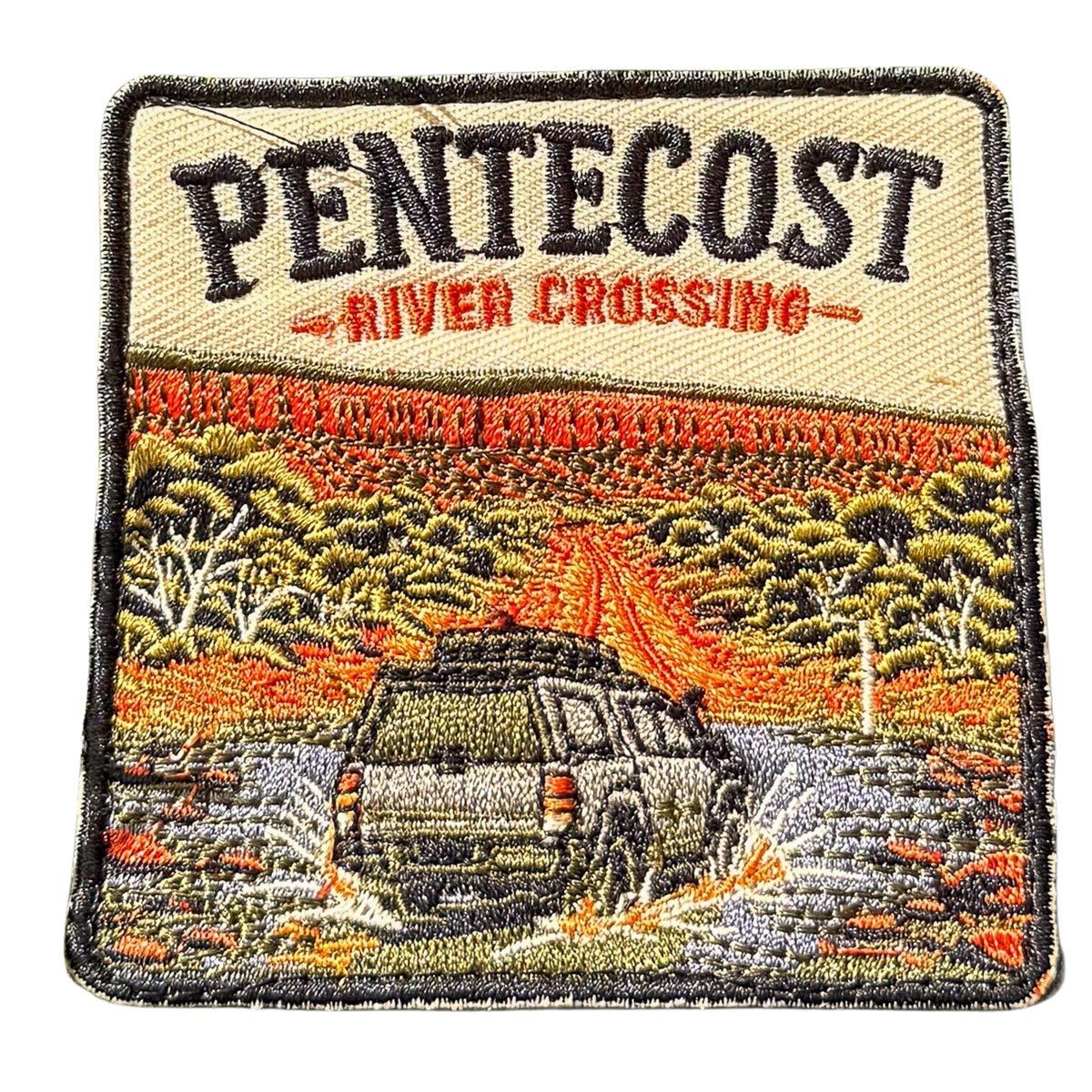 Pentecost River Crossing embroidered travel patch with a four-wheel drive crossing the Pentecost River with the Cockburn Range behind it; photographed on a transparent background.