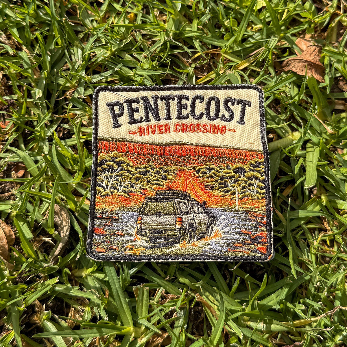 Pentecost River Crossing embroidered travel patch with a four-wheel drive crossing the Pentecost River with the Cockburn Range behind it.