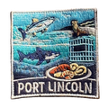 Port Lincoln embroidered travel patch with a tuna, great white shark, sea lion, cage-diving cage and seafood platter; photographed on a transparent background.