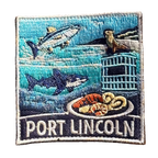 Port Lincoln embroidered travel patch with a tuna, great white shark, sea lion, cage-diving cage and seafood platter; photographed on a transparent background.