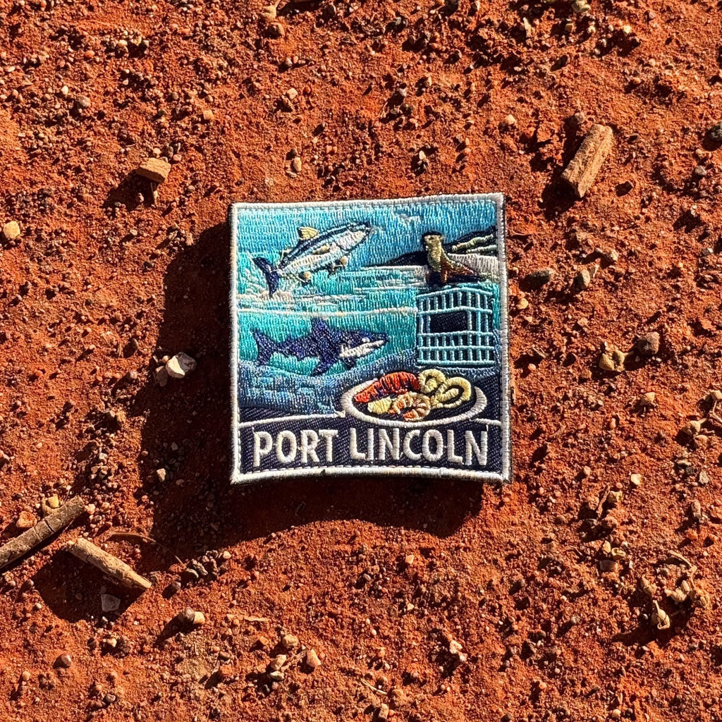 Port Lincoln embroidered travel patch with a tuna, great white shark, sea lion, cage-diving cage and seafood platter.