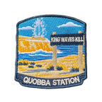 Quobba Blowholes embroidered travel patch with a coastal blowhole spraying above rugged cliffs and ocean; photographed on a transparent background.