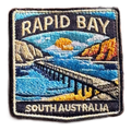 Rapid Bay embroidered travel patch with a long jetty above turquoise coastal water; photographed on a transparent background.