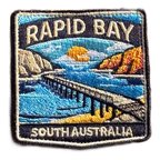 Rapid Bay embroidered travel patch with a long jetty above turquoise coastal water; photographed on a transparent background.