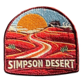 Simpson Desert embroidered travel patch with a four-wheel drive crossing red desert sand dunes; photographed on a transparent background.