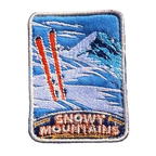 Snowy Mountains embroidered travel patch with snow-covered alpine peaks; photographed on a transparent background.