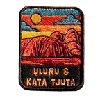 Uluru-Kata Tjuta embroidered travel patch with Uluru and Kata Tjuta rising from red desert country; photographed on a transparent background.