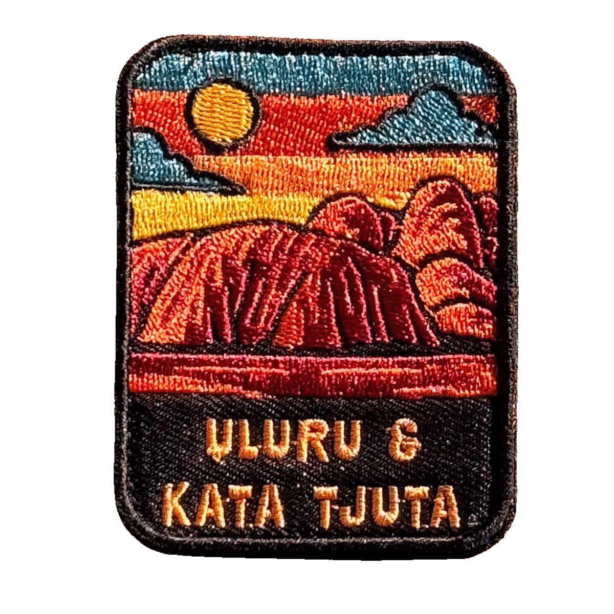 Uluru-Kata Tjuta embroidered travel patch with Uluru and Kata Tjuta rising from red desert country; photographed on a transparent background.