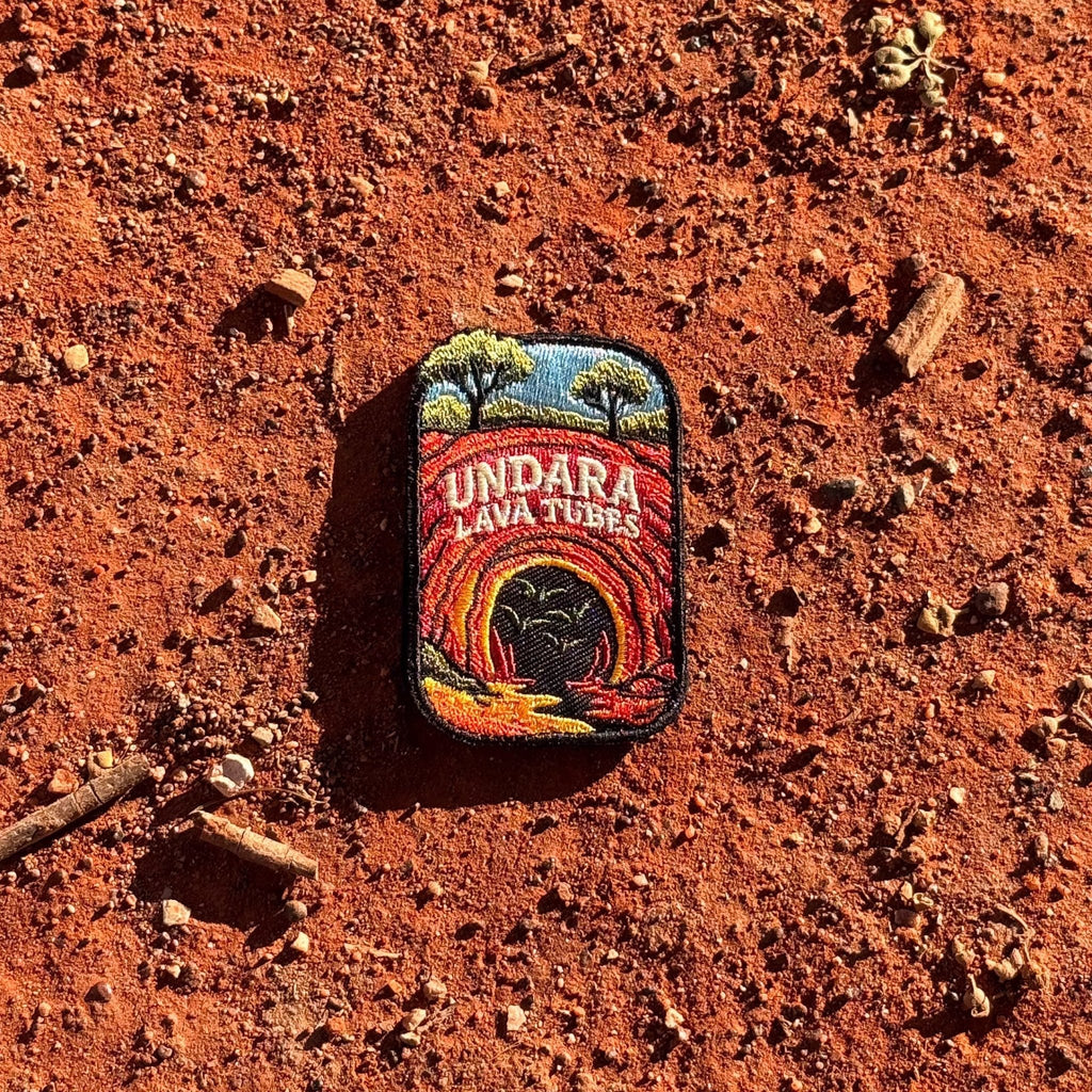 Undara Lava Tubes embroidered travel patch with a lava tube cave opening in an outback landscape.