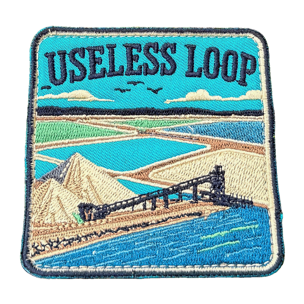 Useless Loop embroidered travel patch with salt flats and blue coastal water; photographed on a transparent background.