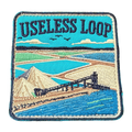 Useless Loop embroidered travel patch with salt flats and blue coastal water; photographed on a transparent background.