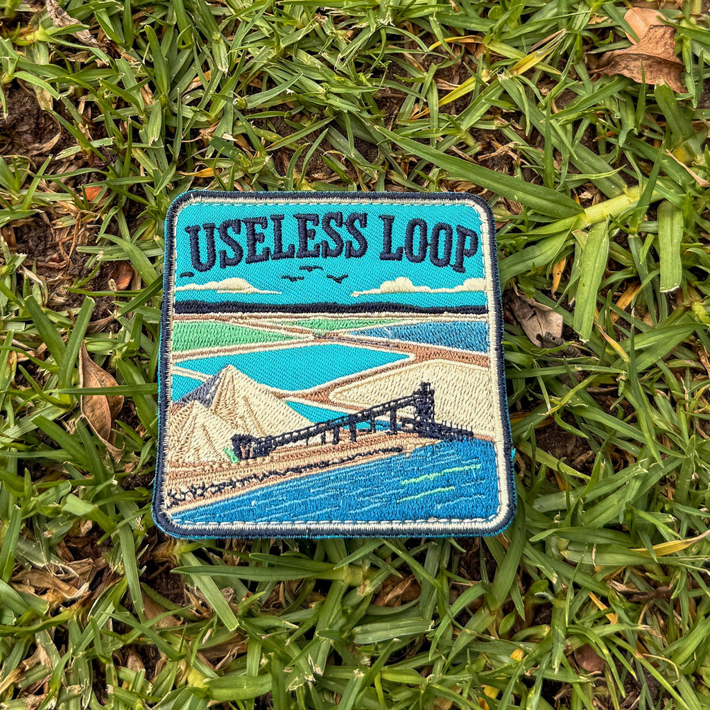 Useless Loop embroidered travel patch with salt flats and blue coastal water.