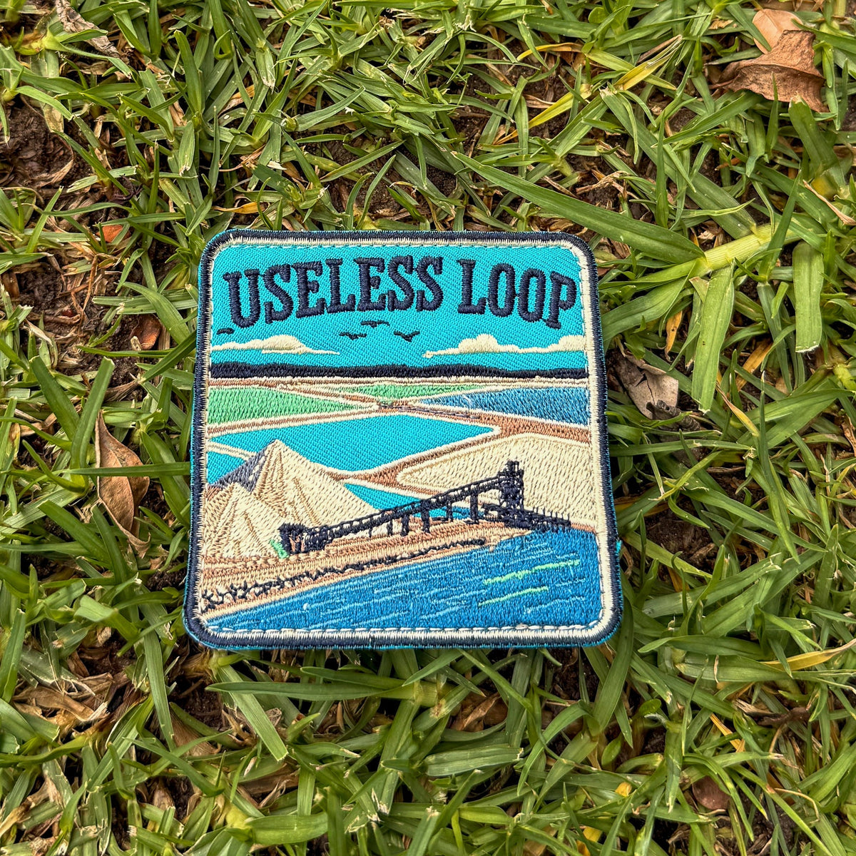 Useless Loop embroidered travel patch with salt flats and blue coastal water.