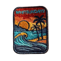 Whitsundays embroidered travel patch with a tropical island beach with palm trees, curling wave and sunset; photographed on a transparent background.