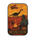 Winton illustrated travel patch design featuring a dinosaur, vintage aircraft and traveller sitting beside a campfire at sunset.